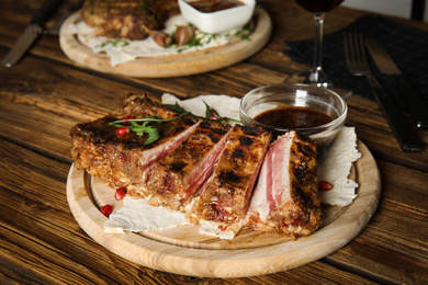 Photo of Delicious grilled ribs served on wooden table