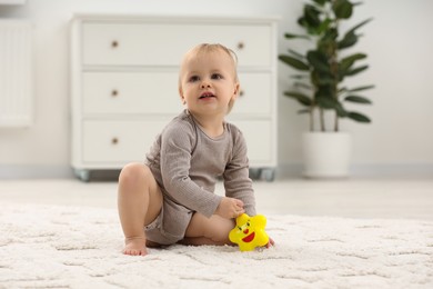 Photo of Children toys. Cute little boy with colorful toy on rug at home