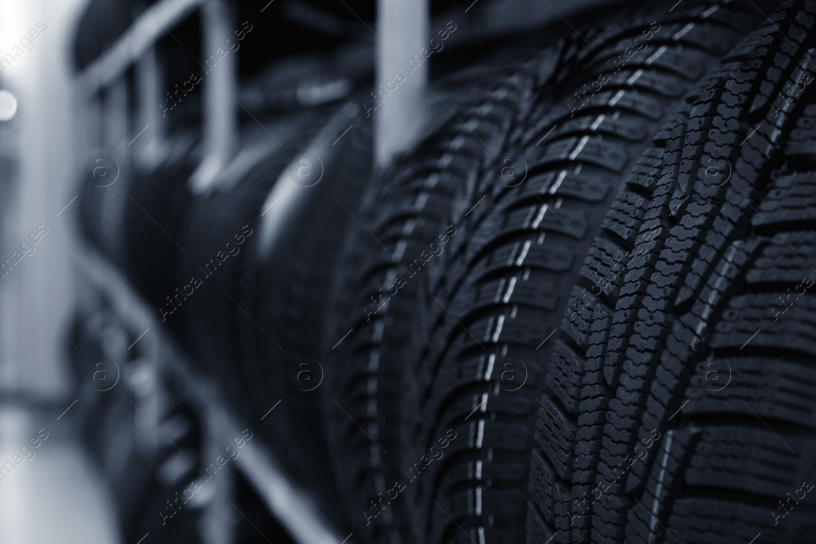 Photo of Car tires on rack in auto store, closeup. Space for text