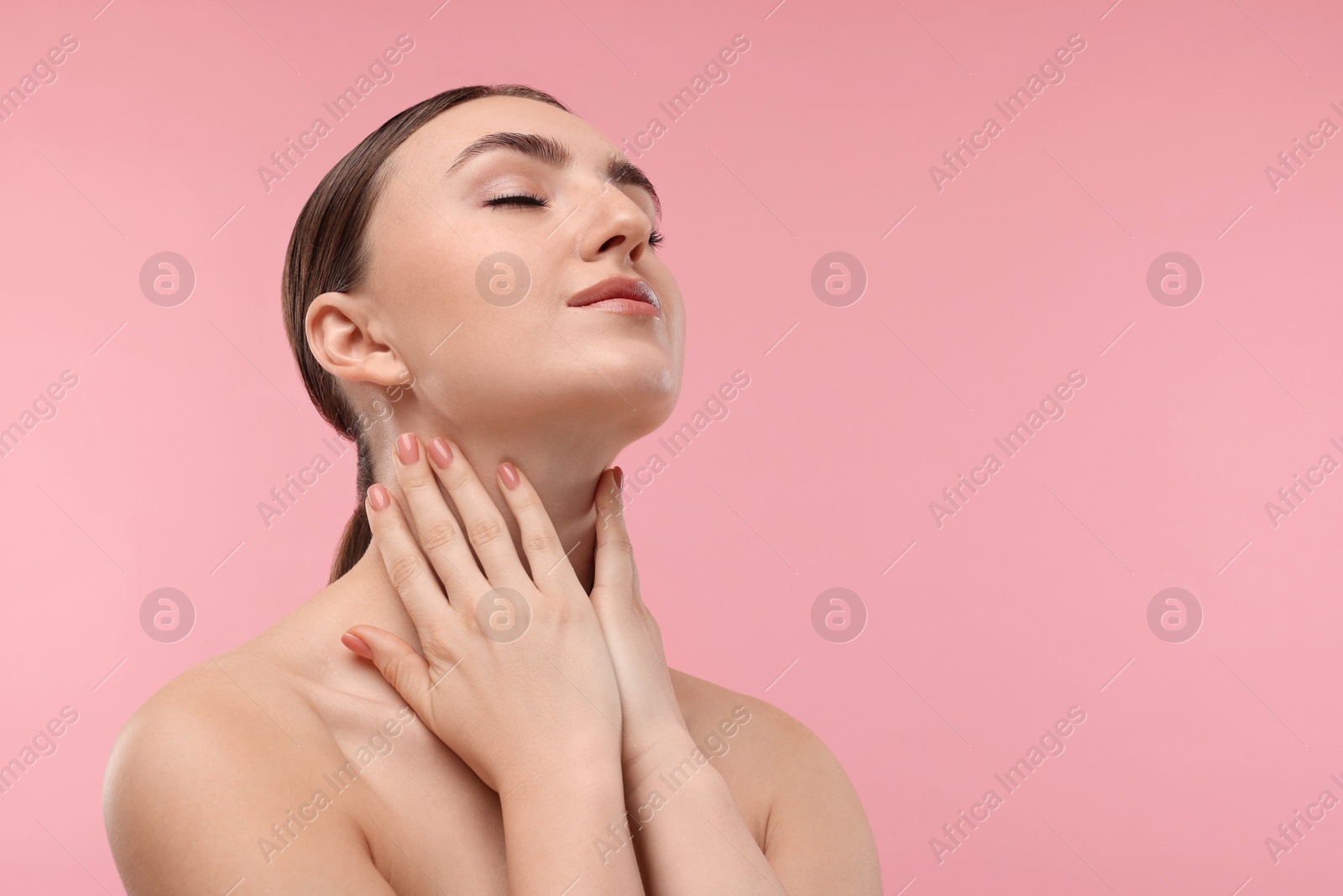 Photo of Beautiful woman touching her neck on pink background. Space for text