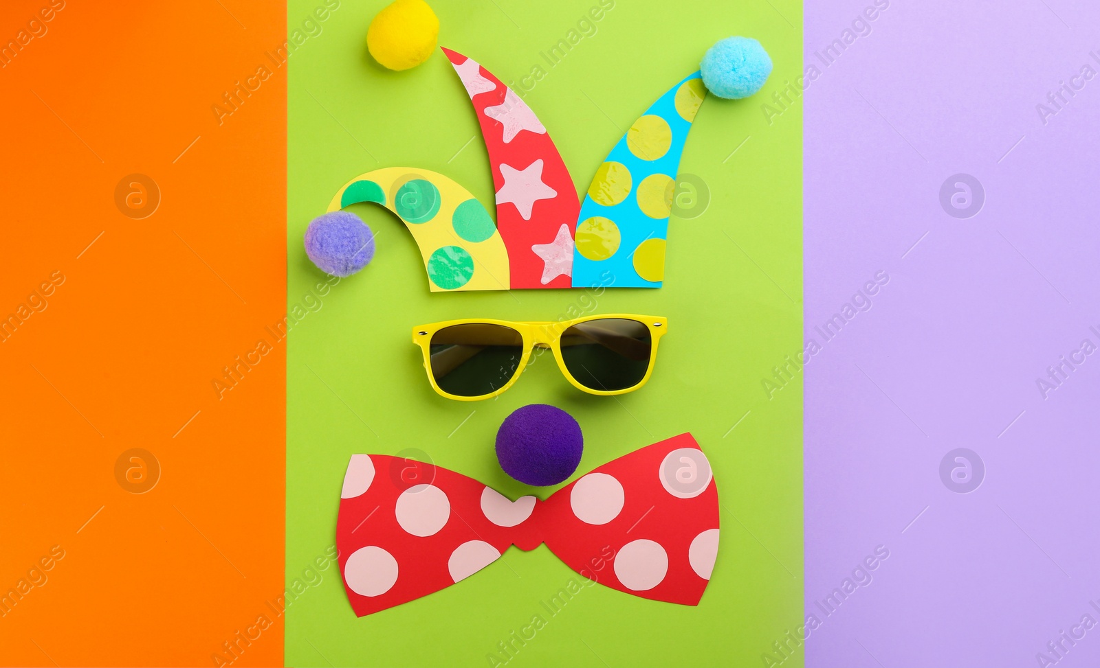 Photo of Flat lay composition clown's face made of sunglasses, hat and bow tie on color background