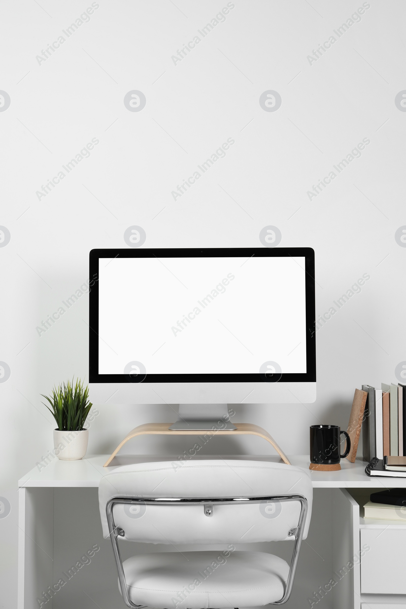 Photo of Cozy workspace with computer and stationery on wooden desk at home