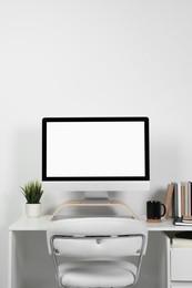 Cozy workspace with computer and stationery on wooden desk at home