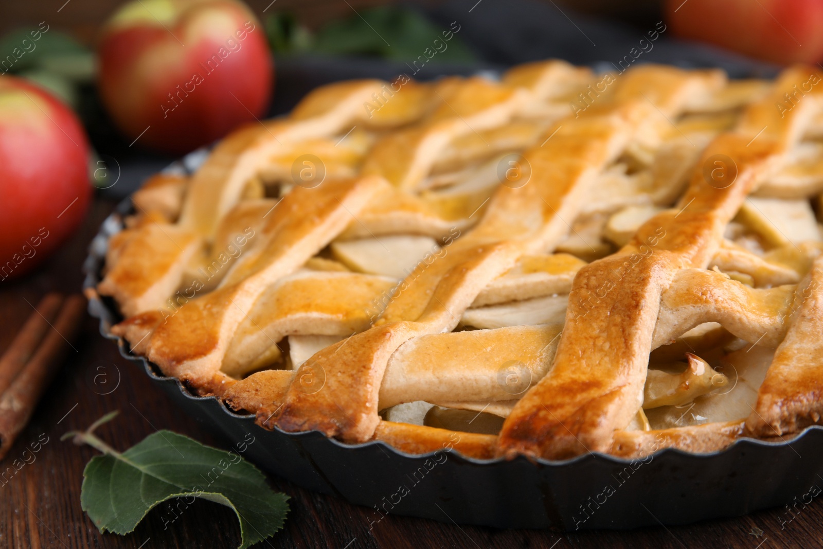 Photo of Delicious traditional apple pie on wooden table, closeup