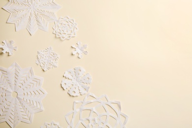 Many paper snowflakes on light background, flat lay. Space for text