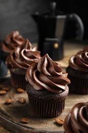 Delicious chocolate cupcakes with cream on wooden table