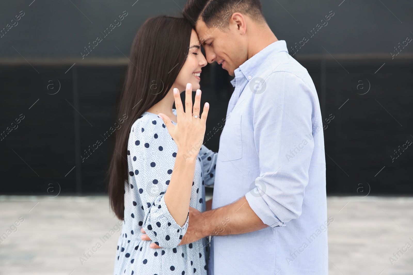 Photo of Lovely couple showing beautiful engagement ring outdoors