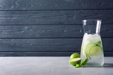 Photo of Natural lemonade with lime in jug on table