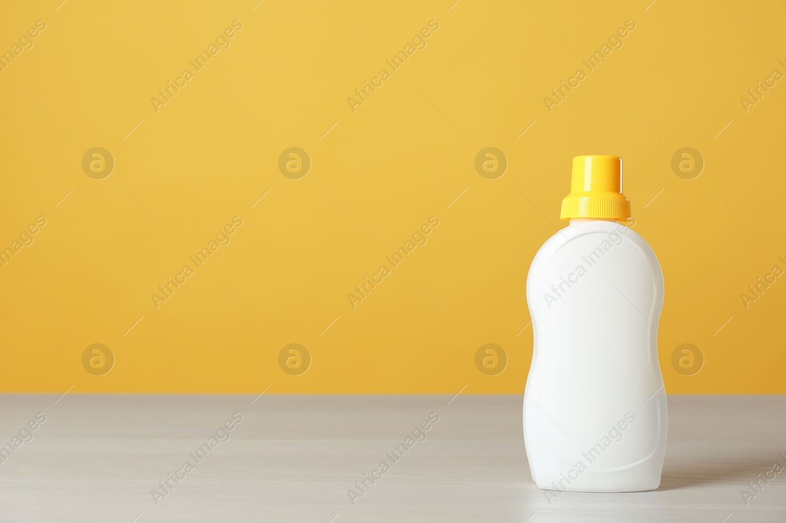 Photo of Bottle of cleaning product on light table. Space for text