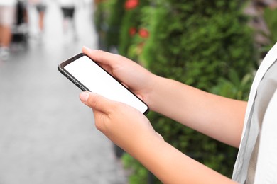 Photo of Young woman using smartphone outdoors, closeup view