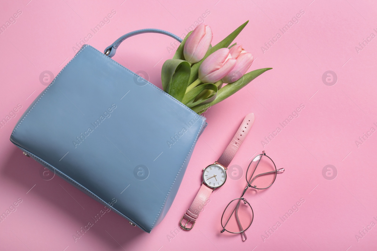 Photo of Flat lay composition with stylish woman's handbag and spring flowers on color background