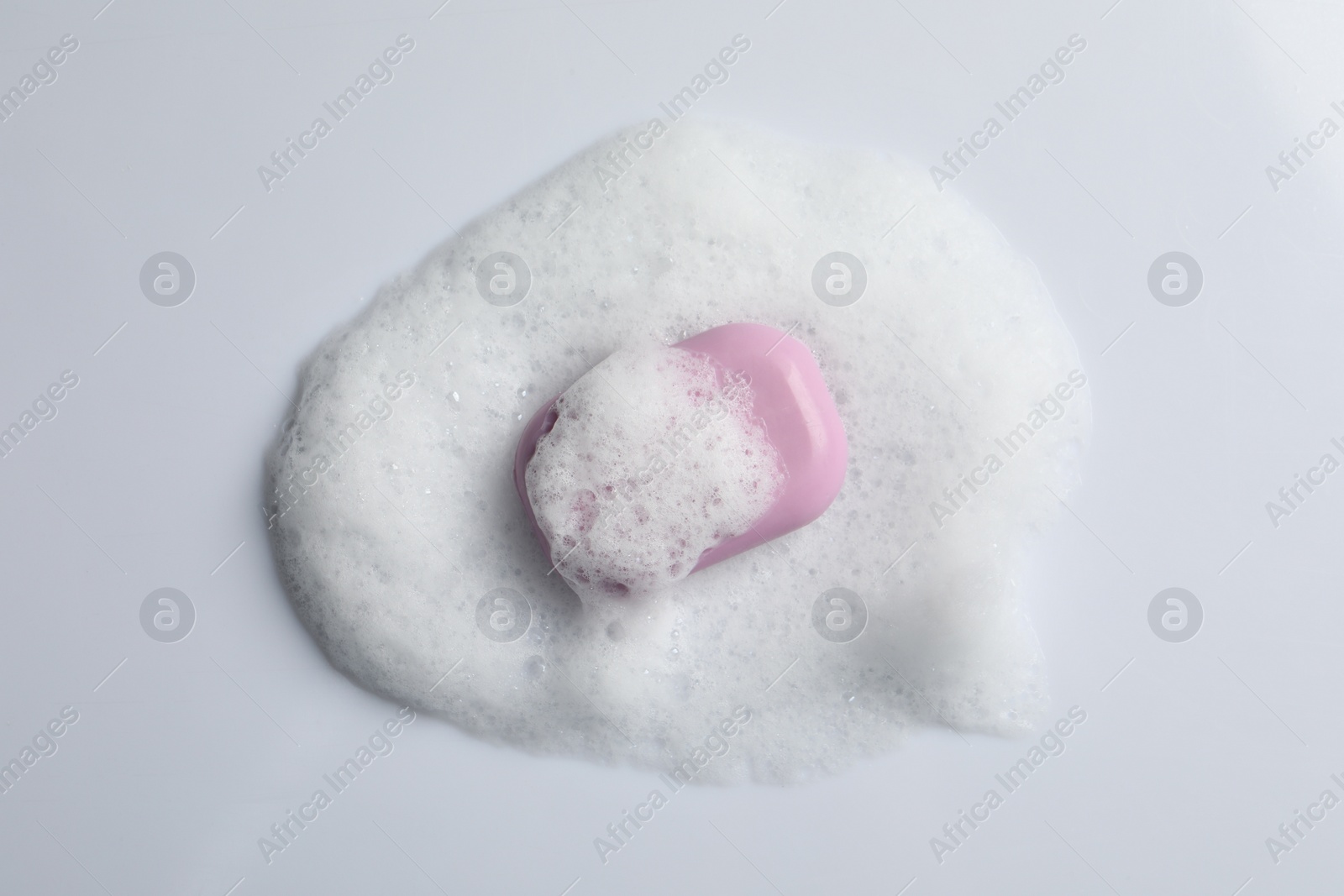 Photo of Soap and fluffy foam on white background, top view