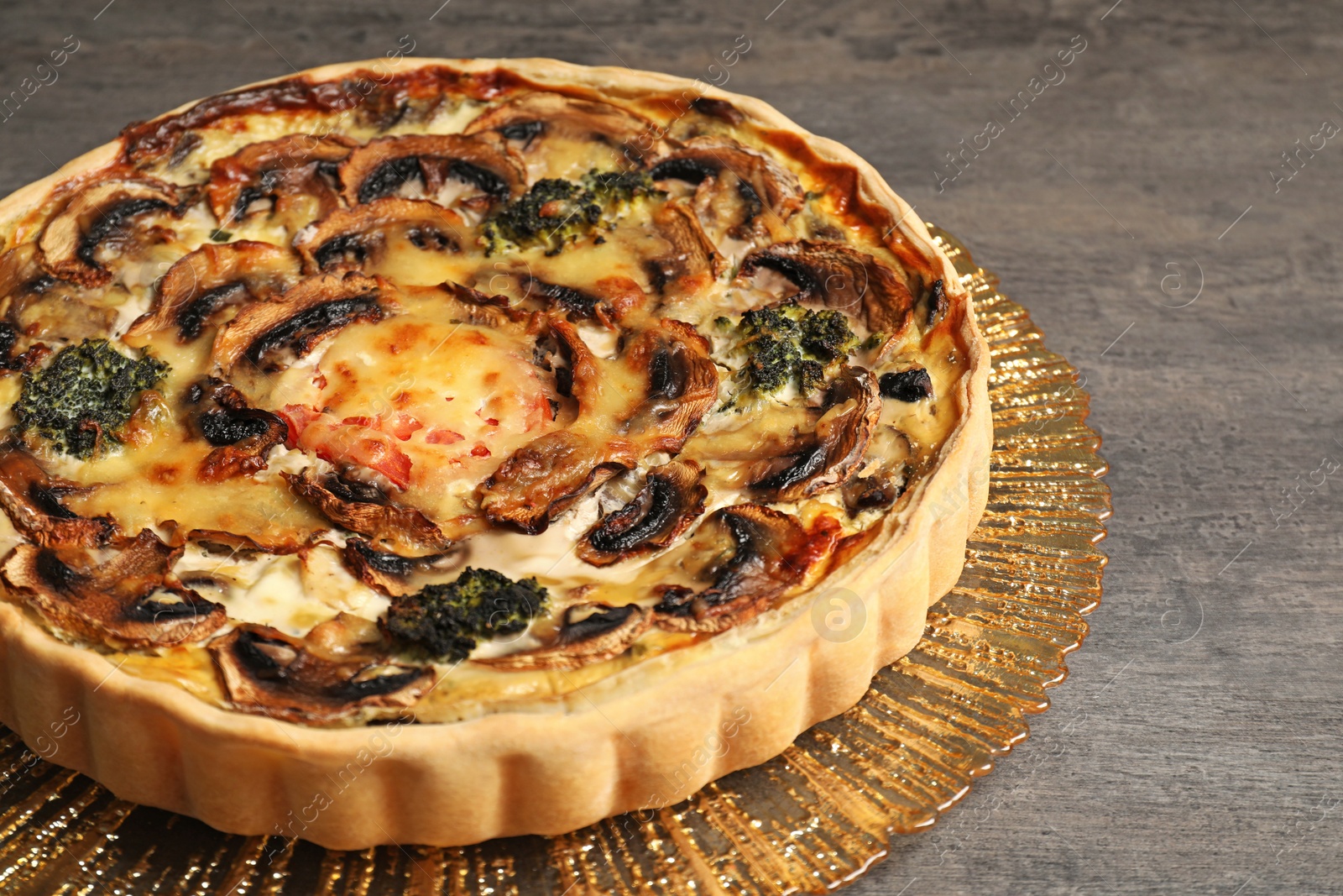 Photo of Delicious quiche with mushrooms on dark grey table, closeup