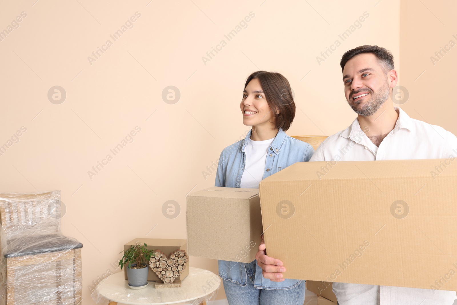 Photo of Happy couple with moving boxes in new apartment