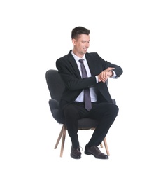 Photo of Handsome young man in suit sitting in armchair on white background