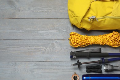 Photo of Flat lay composition with trekking poles and other hiking equipment on wooden background, space for text
