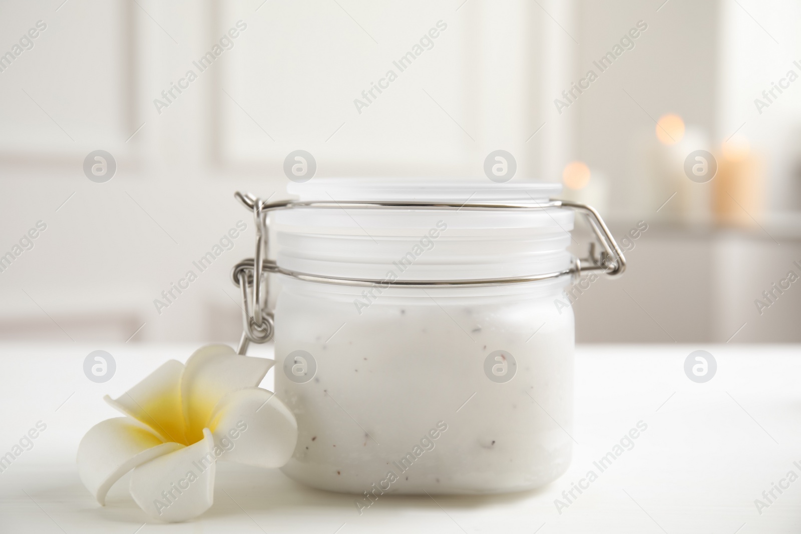 Photo of Salt scrub and plumeria flower on white table