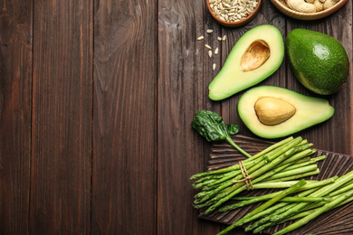 Different products rich in vitamin E on wooden table, flat lay. Space for text