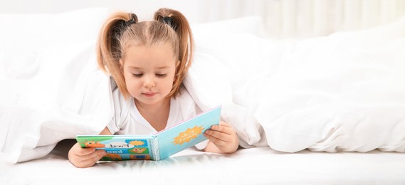 Beautiful little girl with book in bed at home, space for text. Banner design