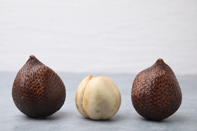 Photo of Fresh salak fruits on light grey table, closeup. Space for text