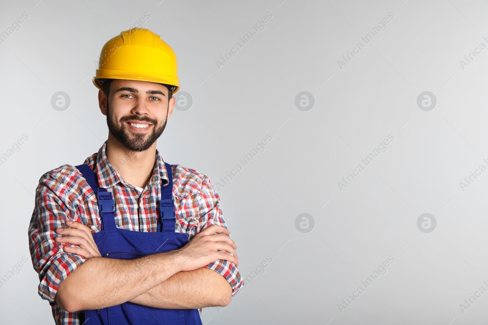 Photo of Portrait of construction worker in uniform on light background, space for text