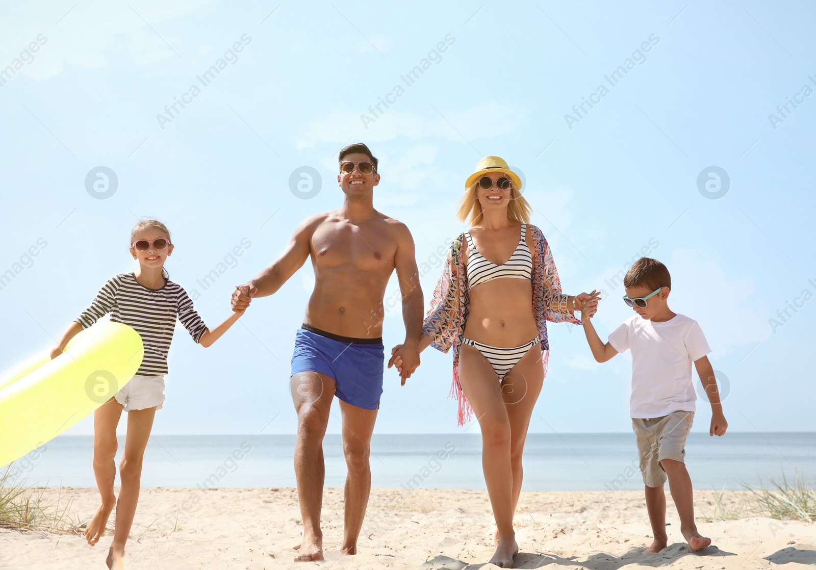 Photo of Family with inflatable ring at beach on sunny day