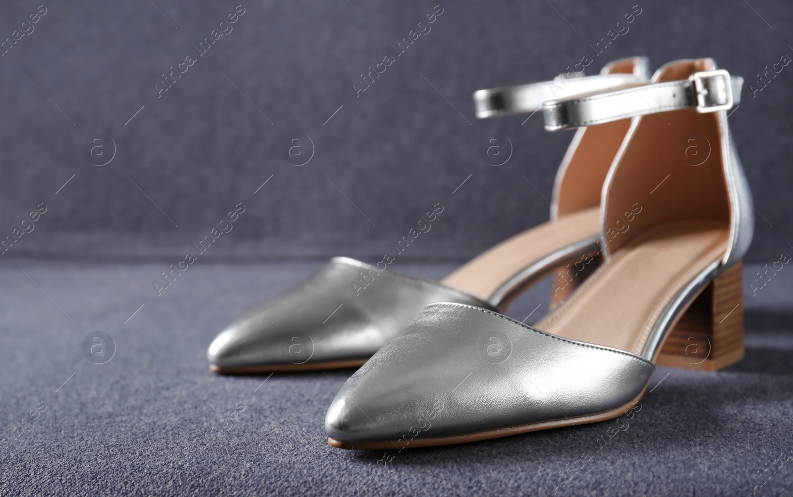 Photo of Pair of elegant female shoes on sofa