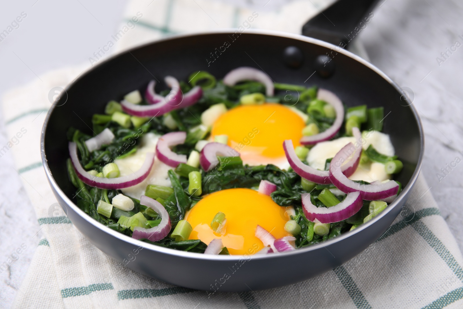 Photo of Tasty green Shakshouka served on white textured table, closeup