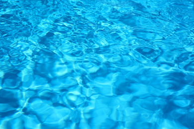 Photo of Texture of blue water in swimming pool as background, closeup