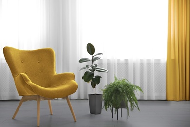 Color of the year 2021. Stylish yellow armchair near window in room