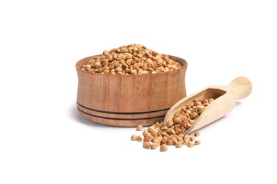 Bowl and scoop with uncooked buckwheat on white background