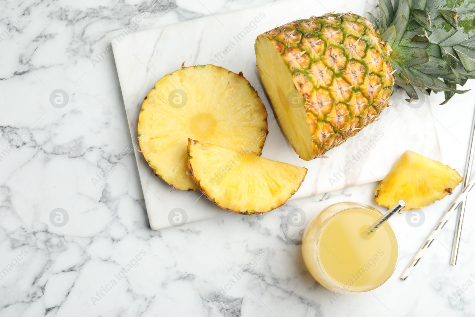 Photo of Delicious pineapple juice and fresh fruit on white marble table, flat lay