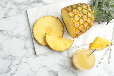 Photo of Delicious pineapple juice and fresh fruit on white marble table, flat lay