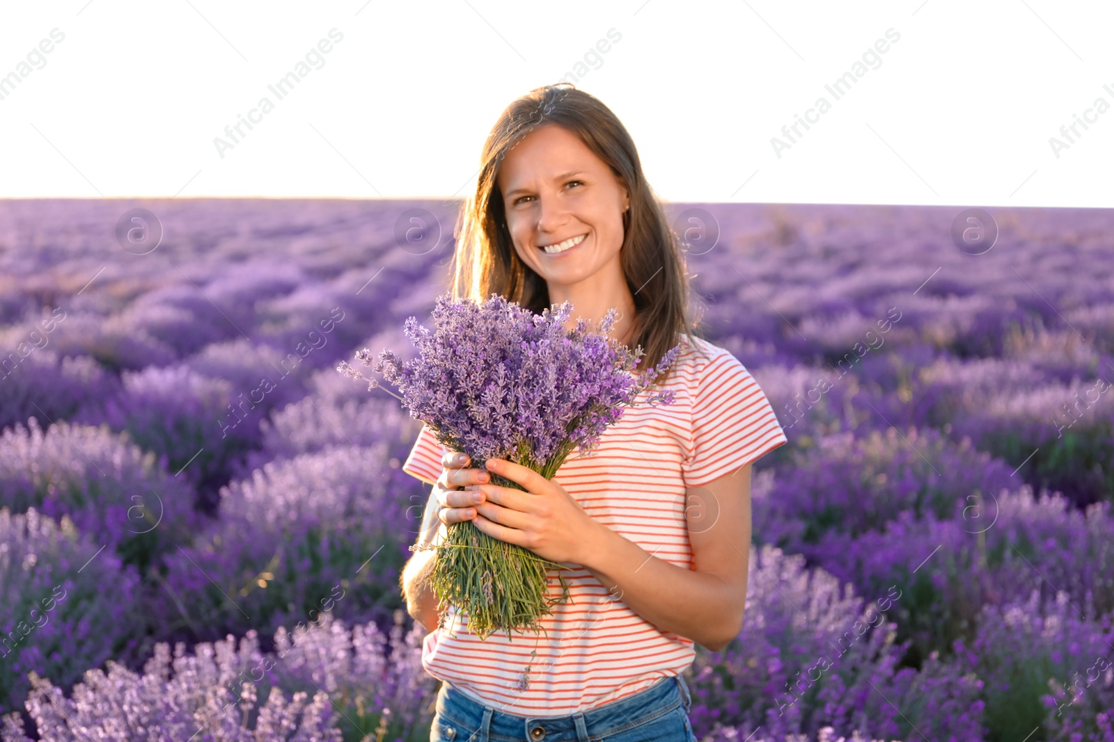 Photo of Young woman with bouquet in lavender field