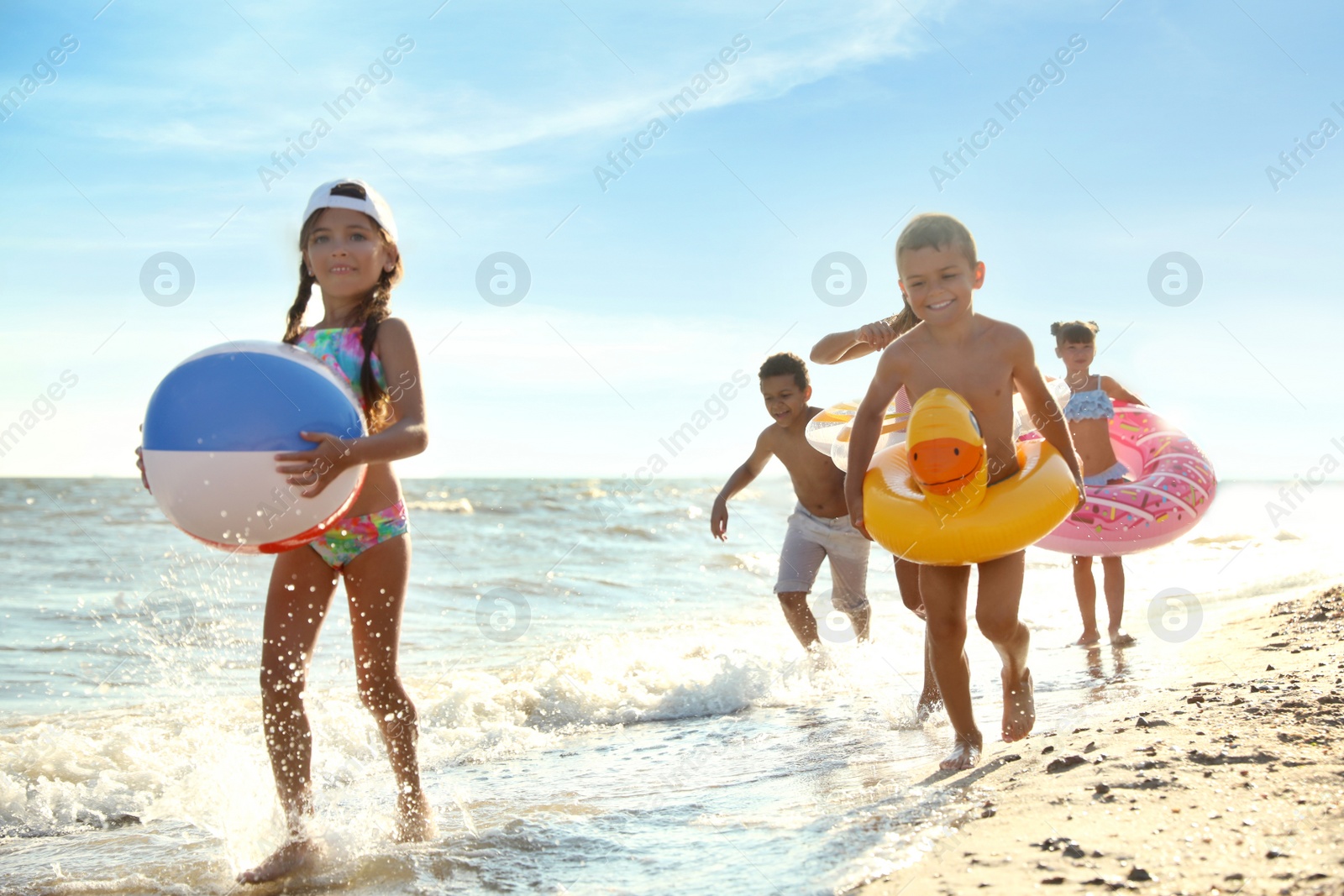 Photo of Cute children enjoying sunny day at beach. Summer camp