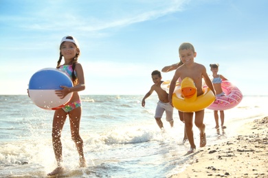 Cute children enjoying sunny day at beach. Summer camp