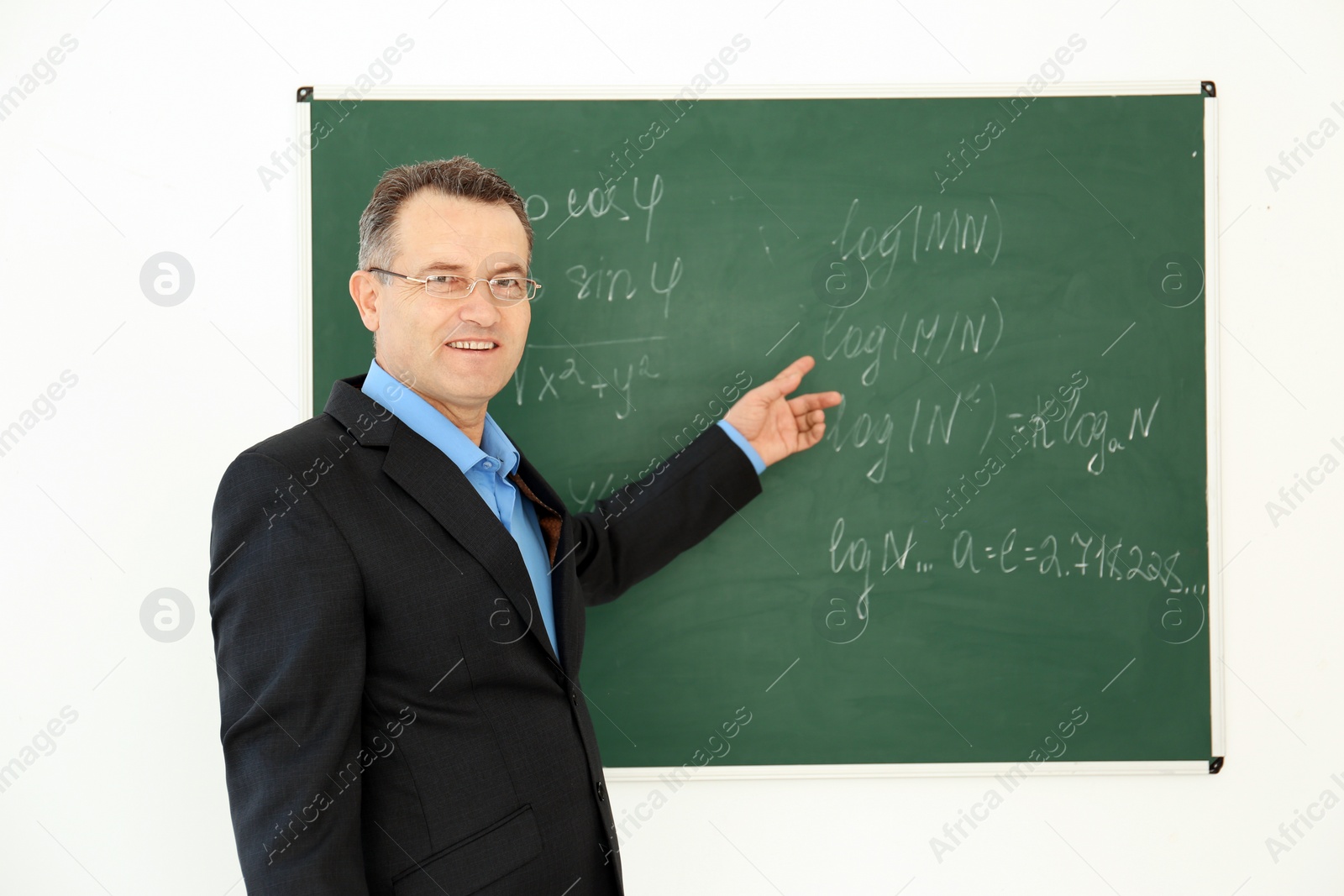 Photo of Portrait of male teacher near blackboard in classroom