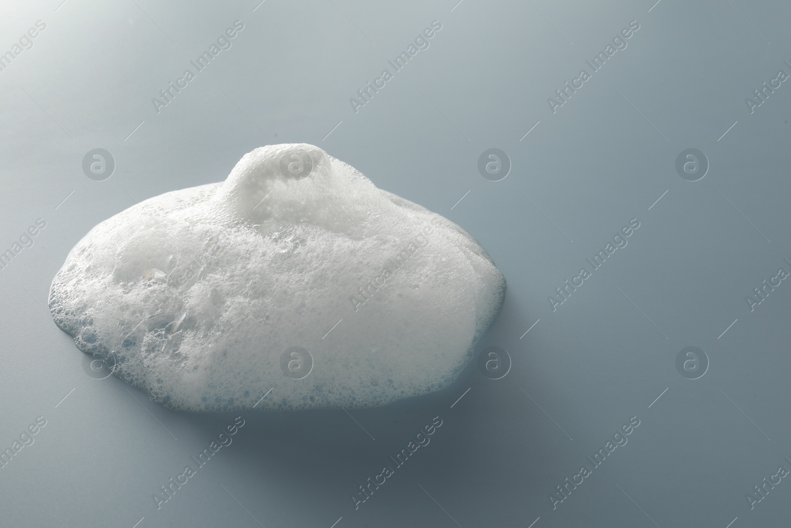 Photo of Spot of white washing foam on color background