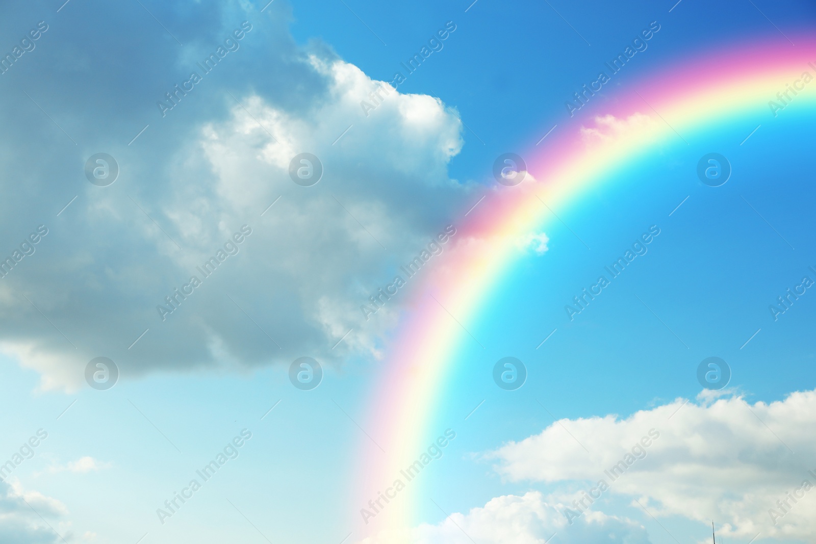 Image of Picturesque view of beautiful rainbow and blue sky on sunny day 