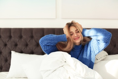 Photo of Beautiful young woman awaking in bed at home. Winter atmosphere