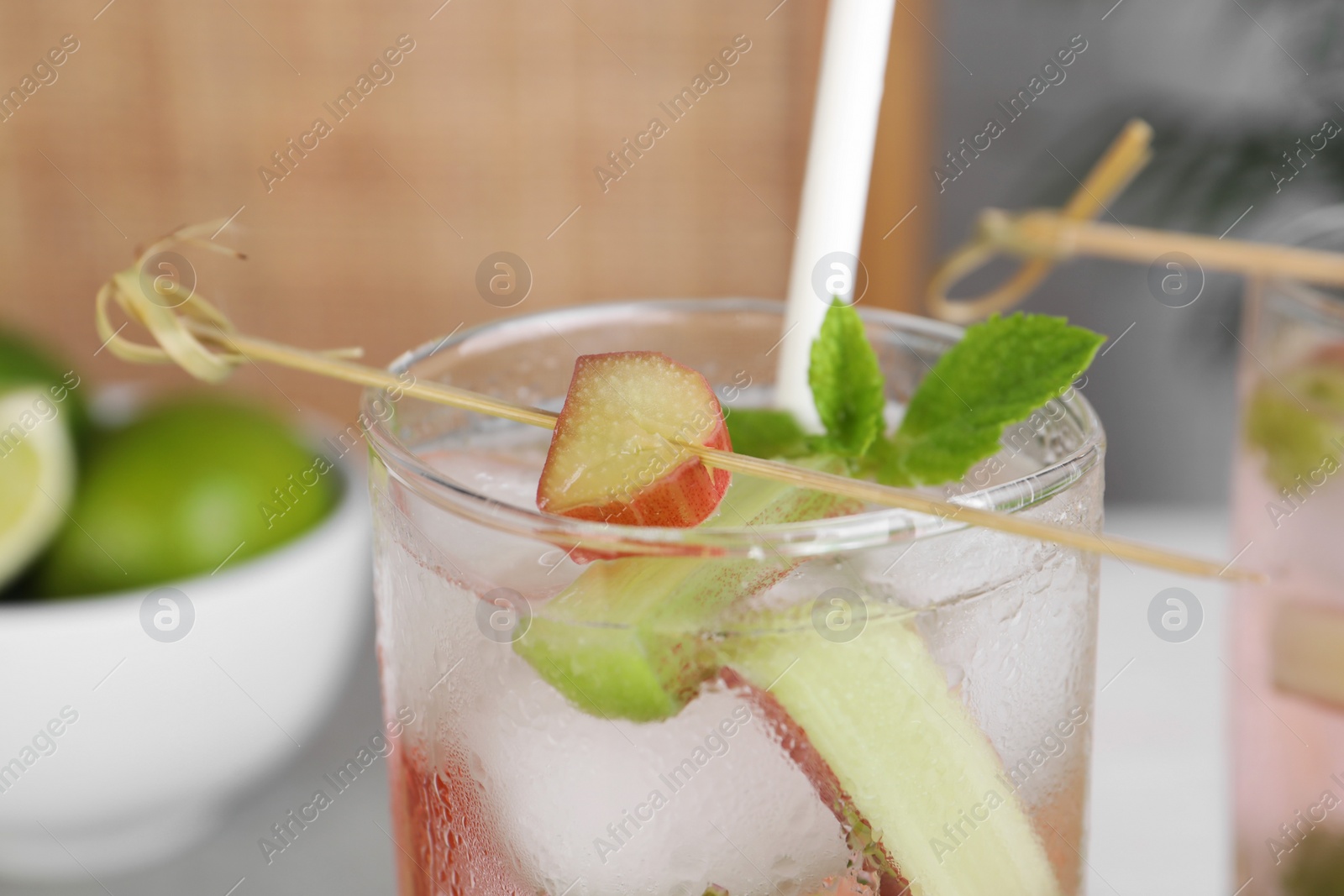 Photo of Glass of tasty rhubarb cocktail with lime, closeup