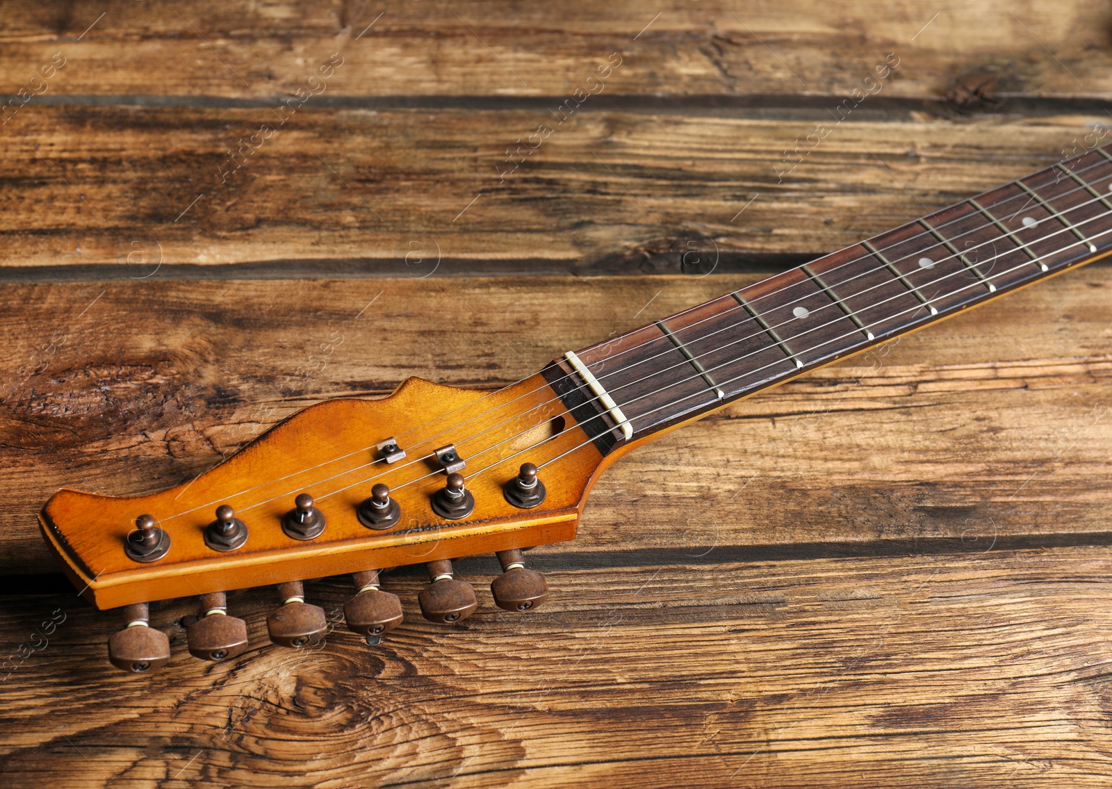 Photo of Modern electric guitar on wooden background. Musical instrument