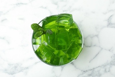 Photo of Kiwi jelly in bowl on marble table, top view