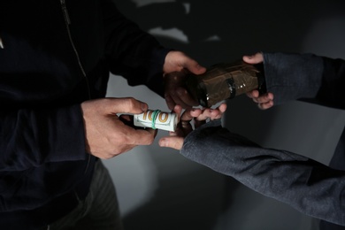 Photo of Addicted man buying drugs from dealer, focus on hands