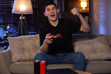 Emotional man playing video games with controller at home