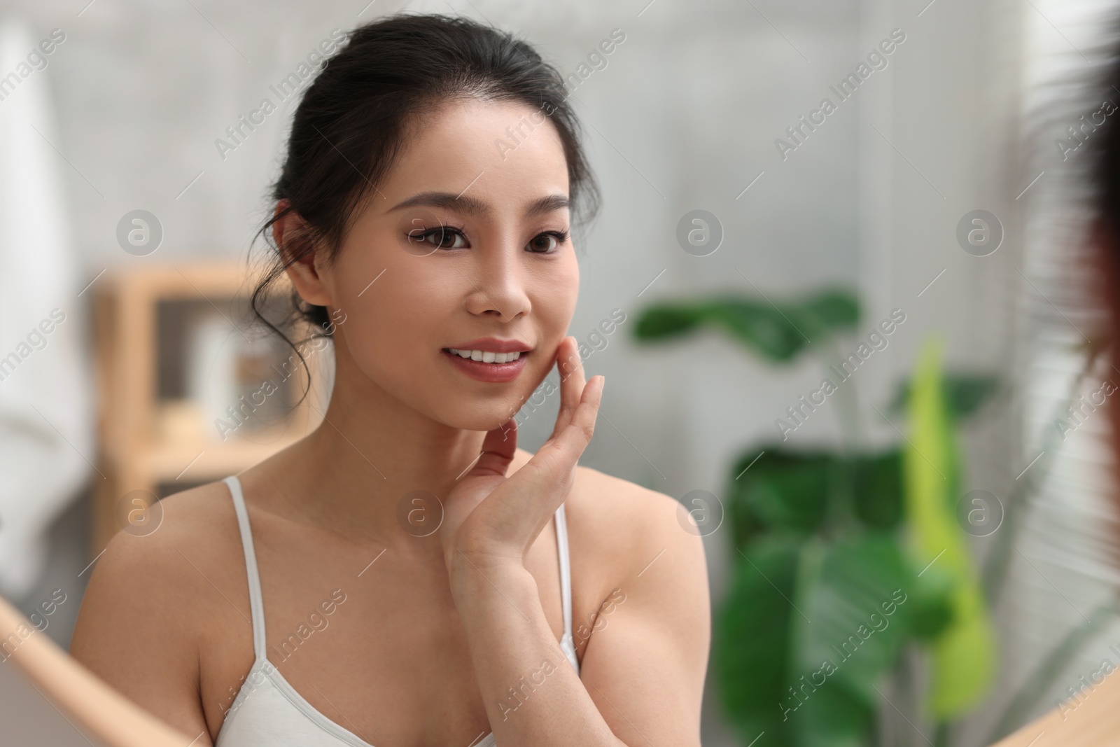 Photo of Portrait of beautiful woman near mirror indoors