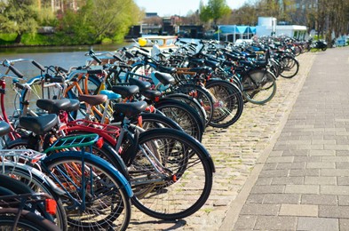 Parking with bicycles near river on sunny day