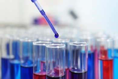 Photo of Dripping reagent into test tube with sample in chemistry laboratory, closeup