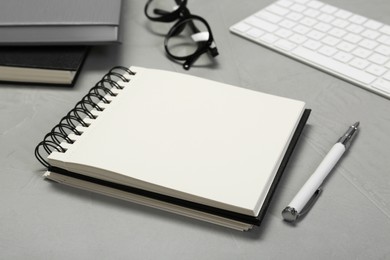 Photo of Open notebook and pen on light grey table