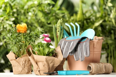 Blooming flowers and gardening equipment on table outdoors